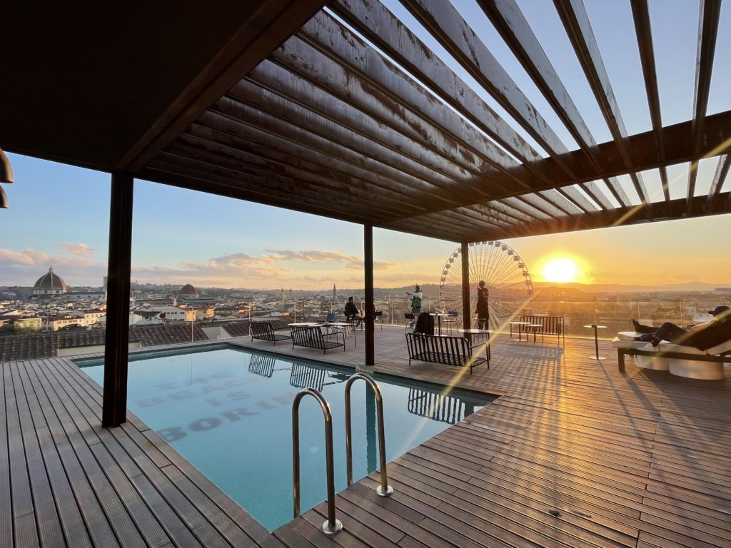 standing on the rooftop at the student hotel during sunset. You can see the Duomo in the distance right over the rooftop pool